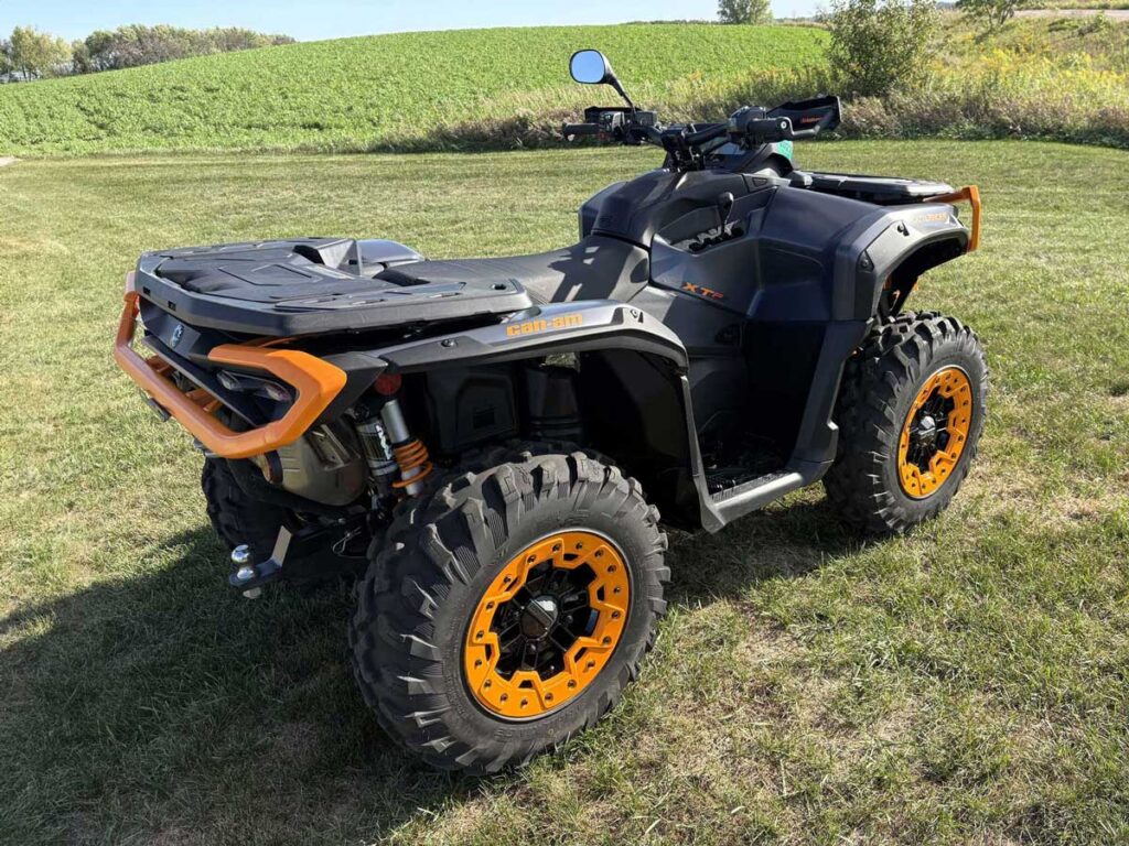 Black and orange Can-Am ATV parked on grass