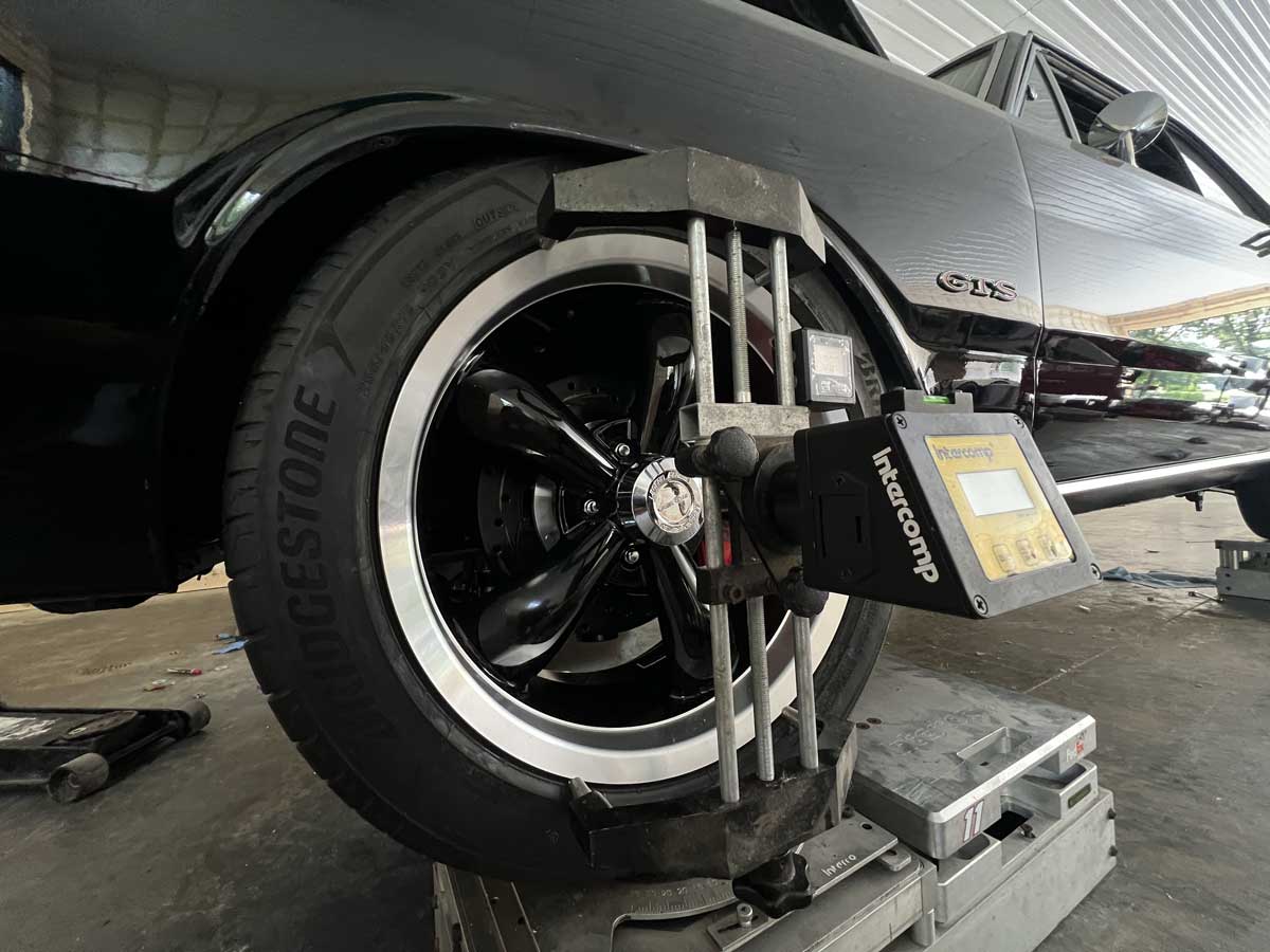 Black classic car wheel undergoing alignment service