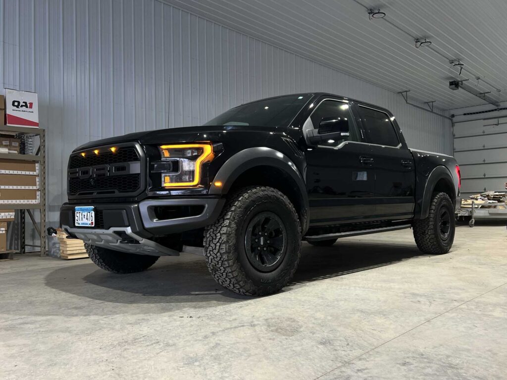 Black Ford F-150 Raptor parked inside a workshop