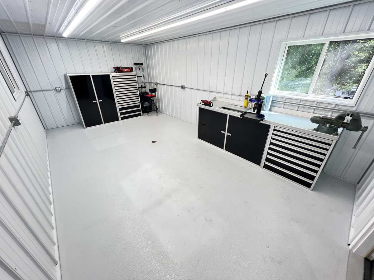 Organized metal workshop with cabinets, tool drawers, and workbench