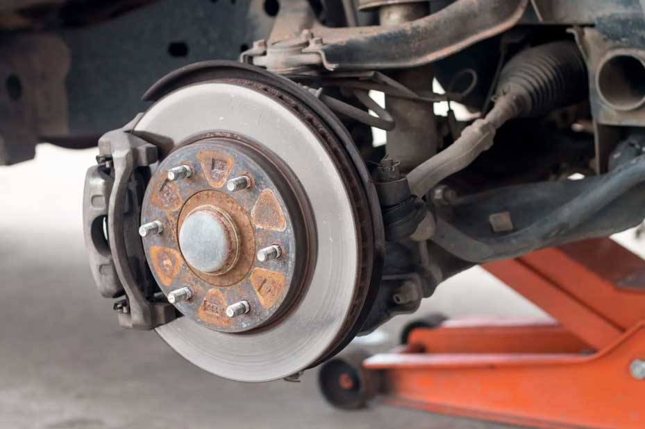 Vehicle brake rotor and rusty wheel hub on lift