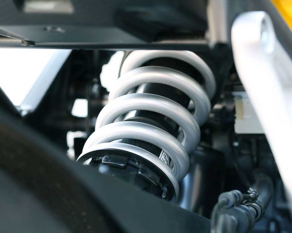 Close-up of a vehicle suspension coil spring and shock absorber